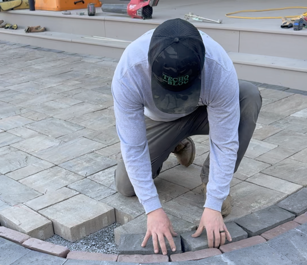 Professional hardscaping team installing a retaining wall